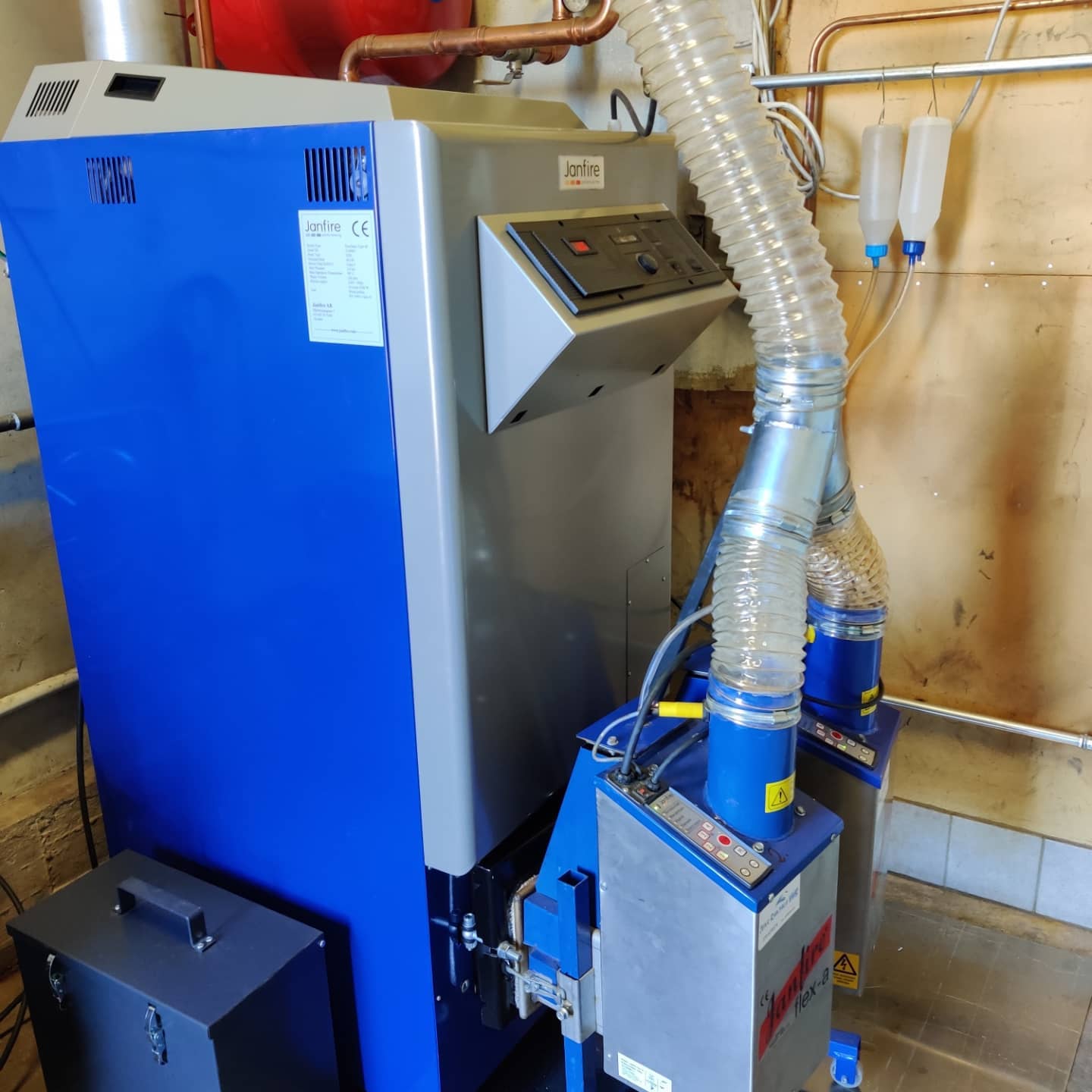 Janfire Duoflame 46 kW snett från sidan, två pelletsbrännare Janfire flex-a, nedfallsslang, pellets