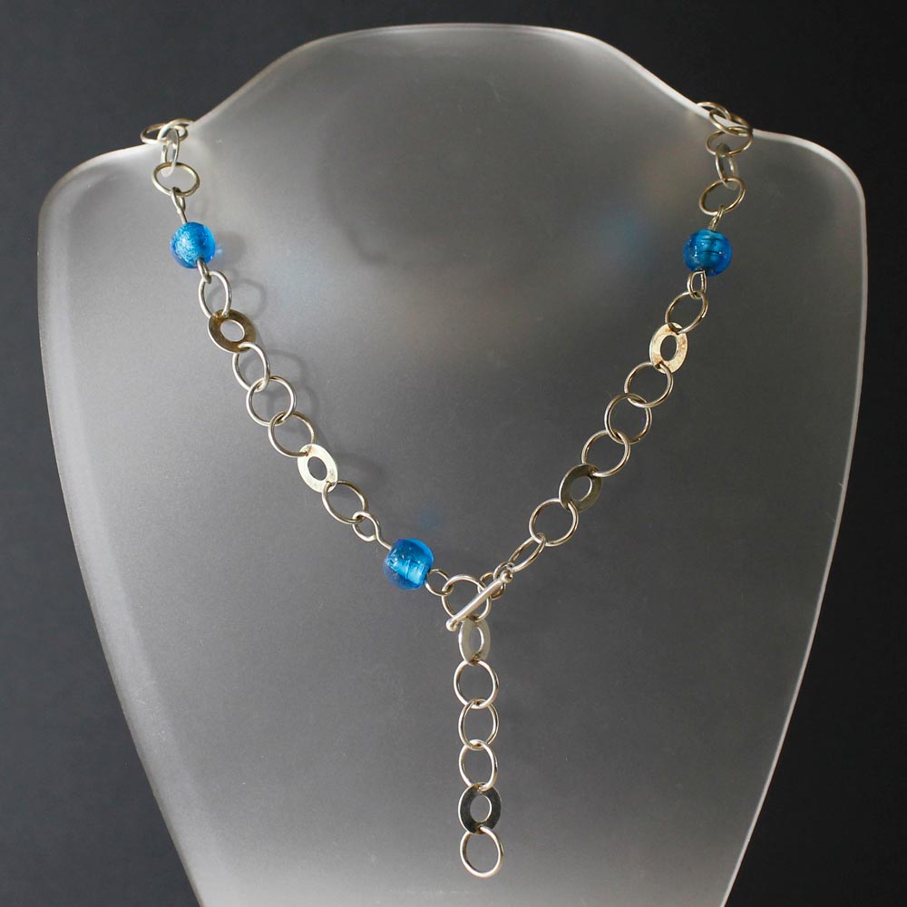 Ett silverhalsband med handgjorda glaspärlor i turkost. 