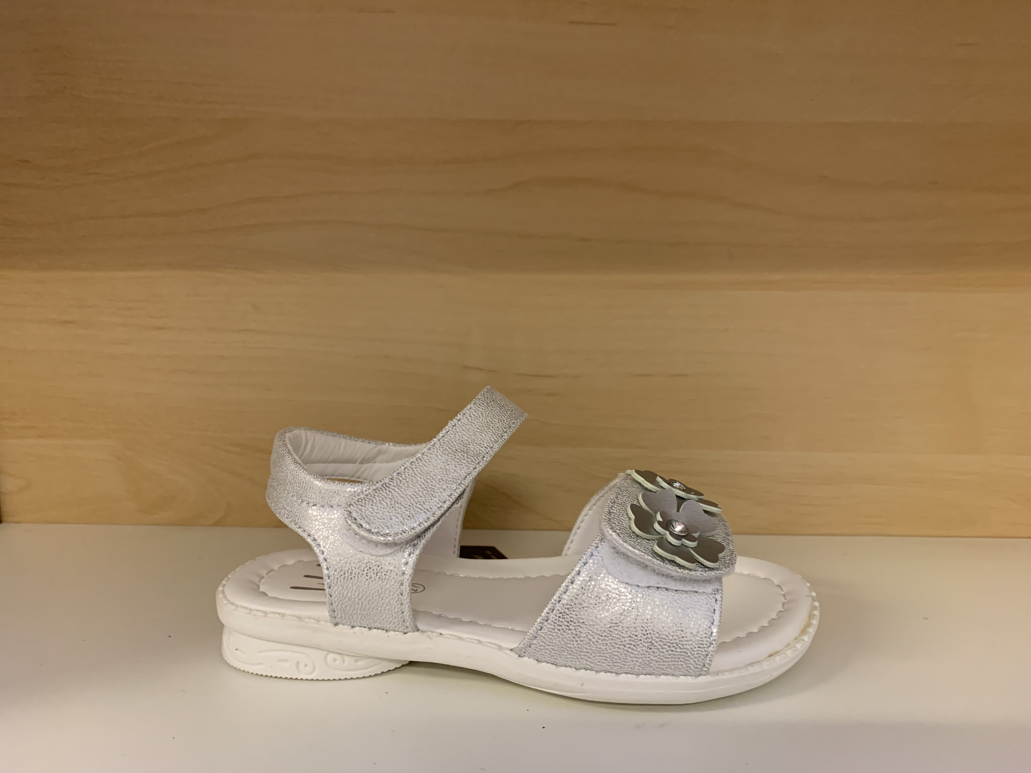 Barnsandal med kardborband både över vristen och foten. Silver och vit.