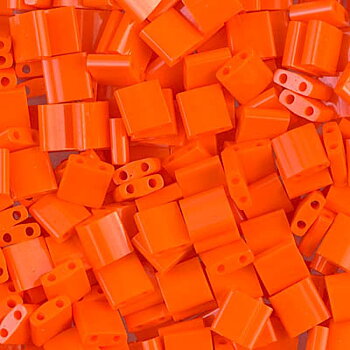 Miyuki Tila glaspärlor i färgen Opaque Orange TL0406, fyrkantiga 5x5 mm pärlor med två hål, visade i närbild.