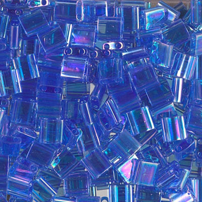 Miyuki Tila glaspärlor i färgen Transparent Light Sapphire AB, fyrkantiga 5x5 mm pärlor med två hål, visade i närbild.
