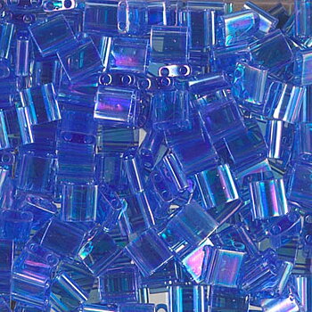 Miyuki Tila glaspärlor i färgen Transparent Light Sapphire AB, fyrkantiga 5x5 mm pärlor med två hål, visade i närbild.
