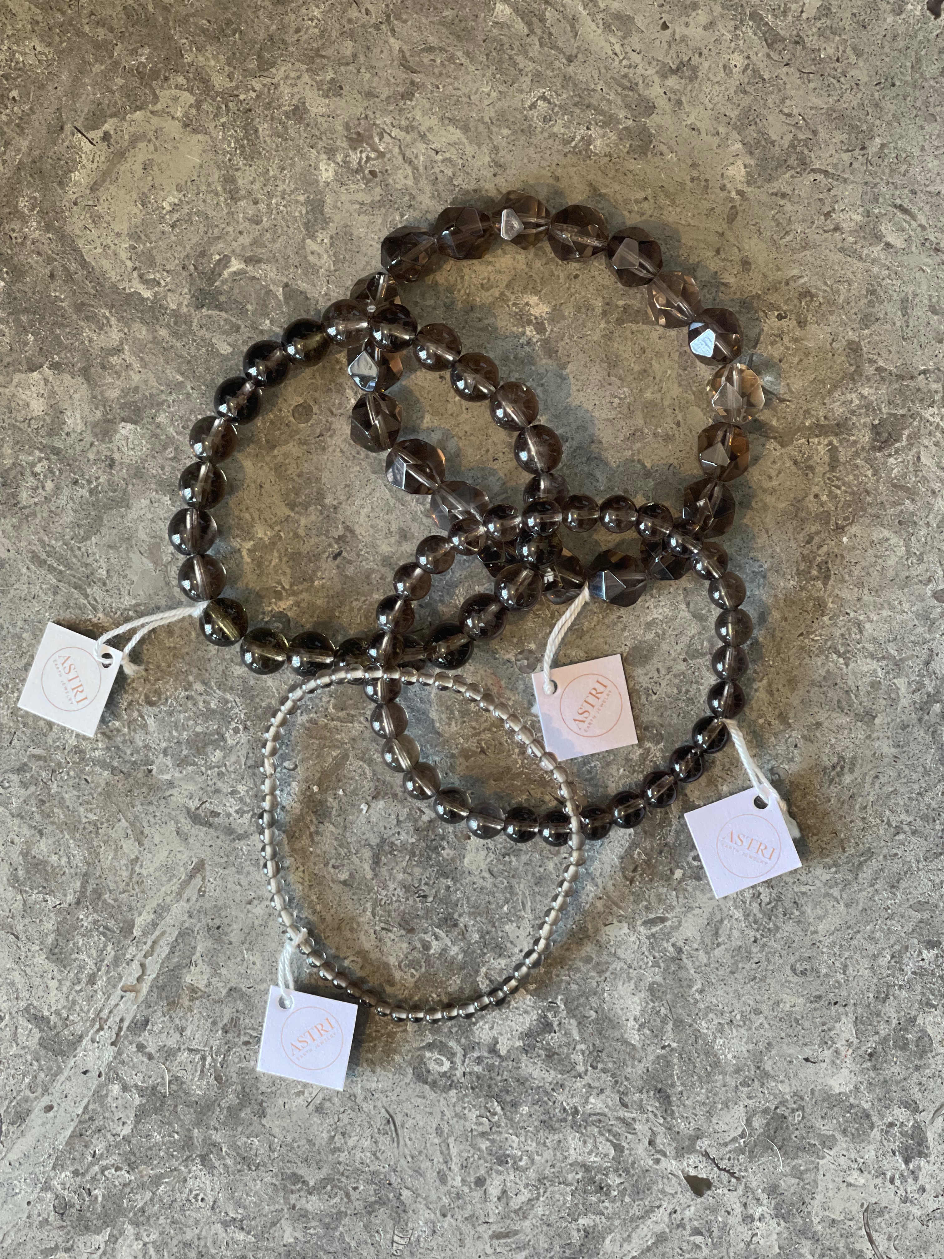 Armband av rökkvarts pärlor. Fyra olika storlekar av pärlor. 