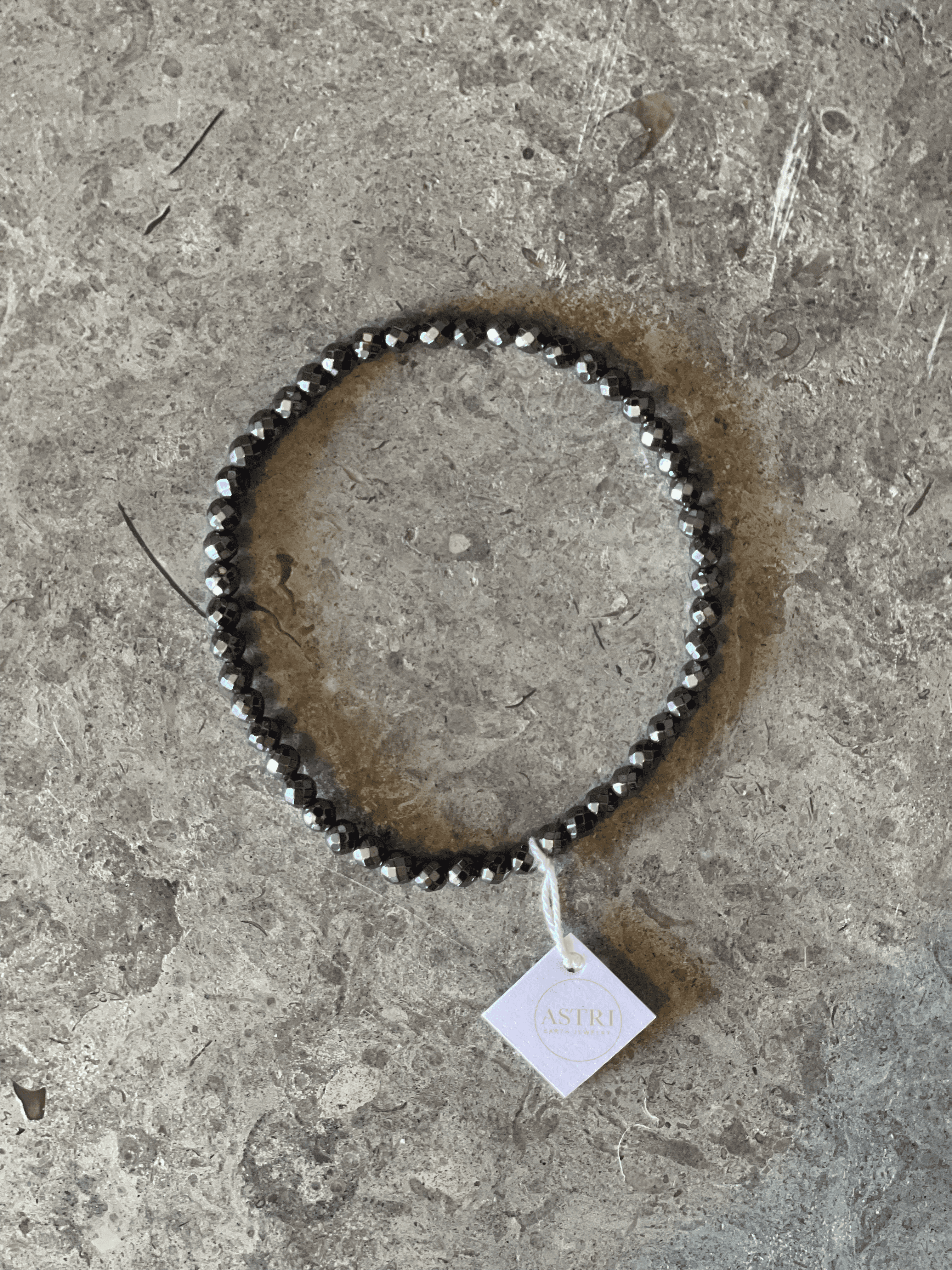 Handgjort armband med mindre pärlor av facettslipad Amestist - mörkgrå med skiftningar i svart och glitter