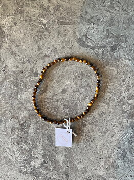 Armband som är handgjort av halväldelstenen Tigeröga. Detta armband har en aning mindre pärlor, 3 mm.