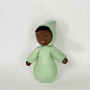 Mörk baby med mörkt hår och grön pyjamas - en liten handgjord dekorationsfigur av ull 