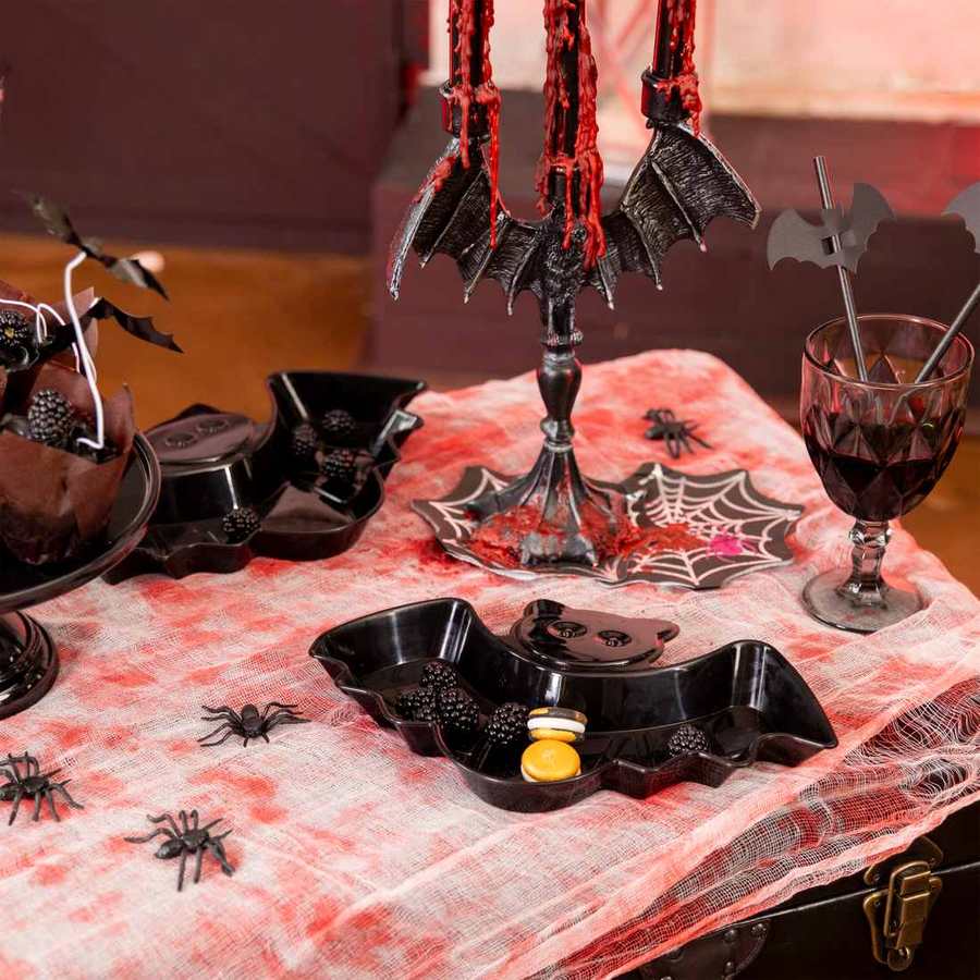 Halloween-dukning med svart fladdermusfat och spindeldekorationer