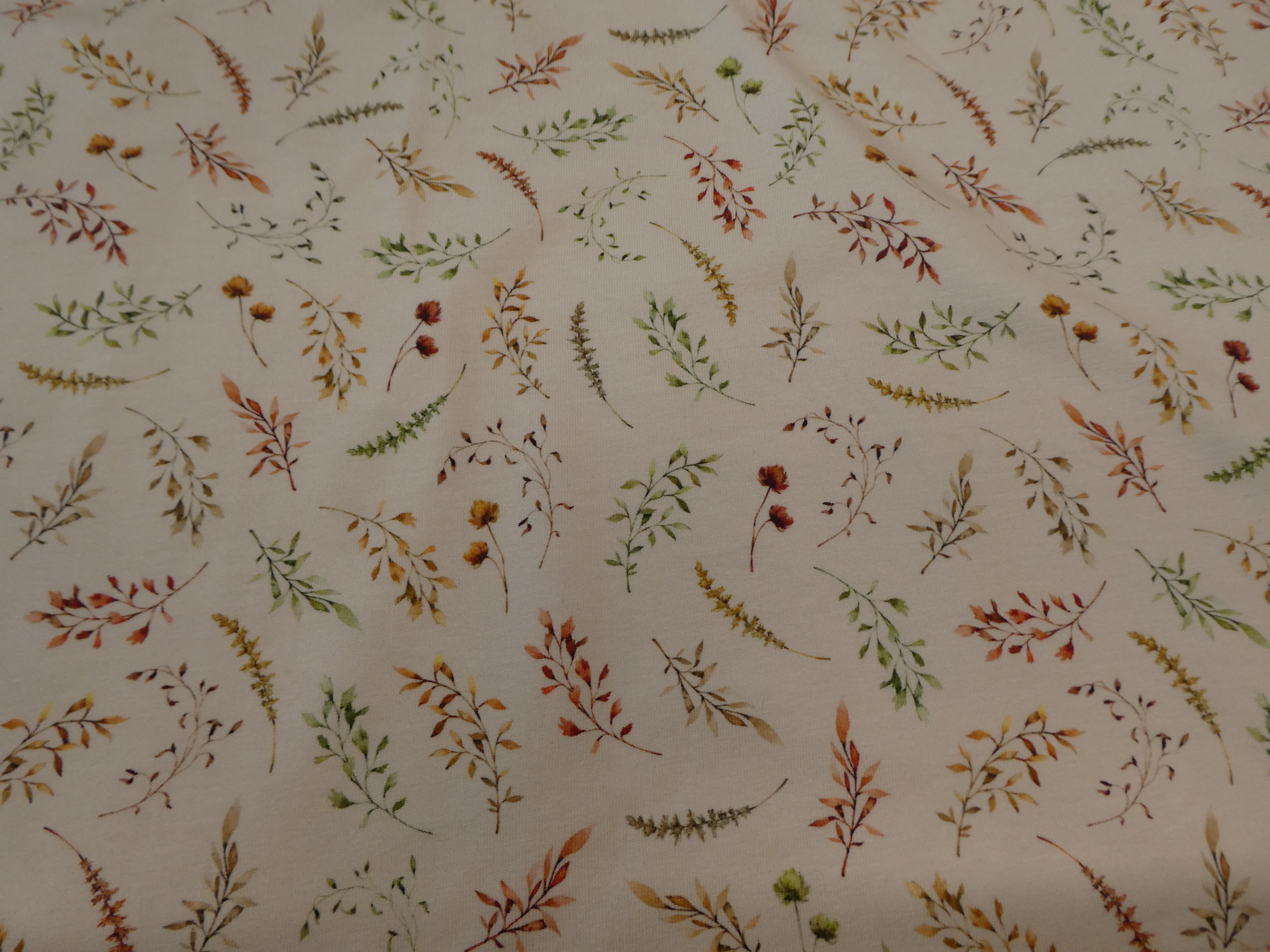 ljus beige botten med stå och små blommor i rost och gröna toner