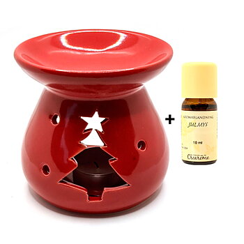 rödglaserad aromalykta med jultema och bredvid en eterisk olja med julig doft