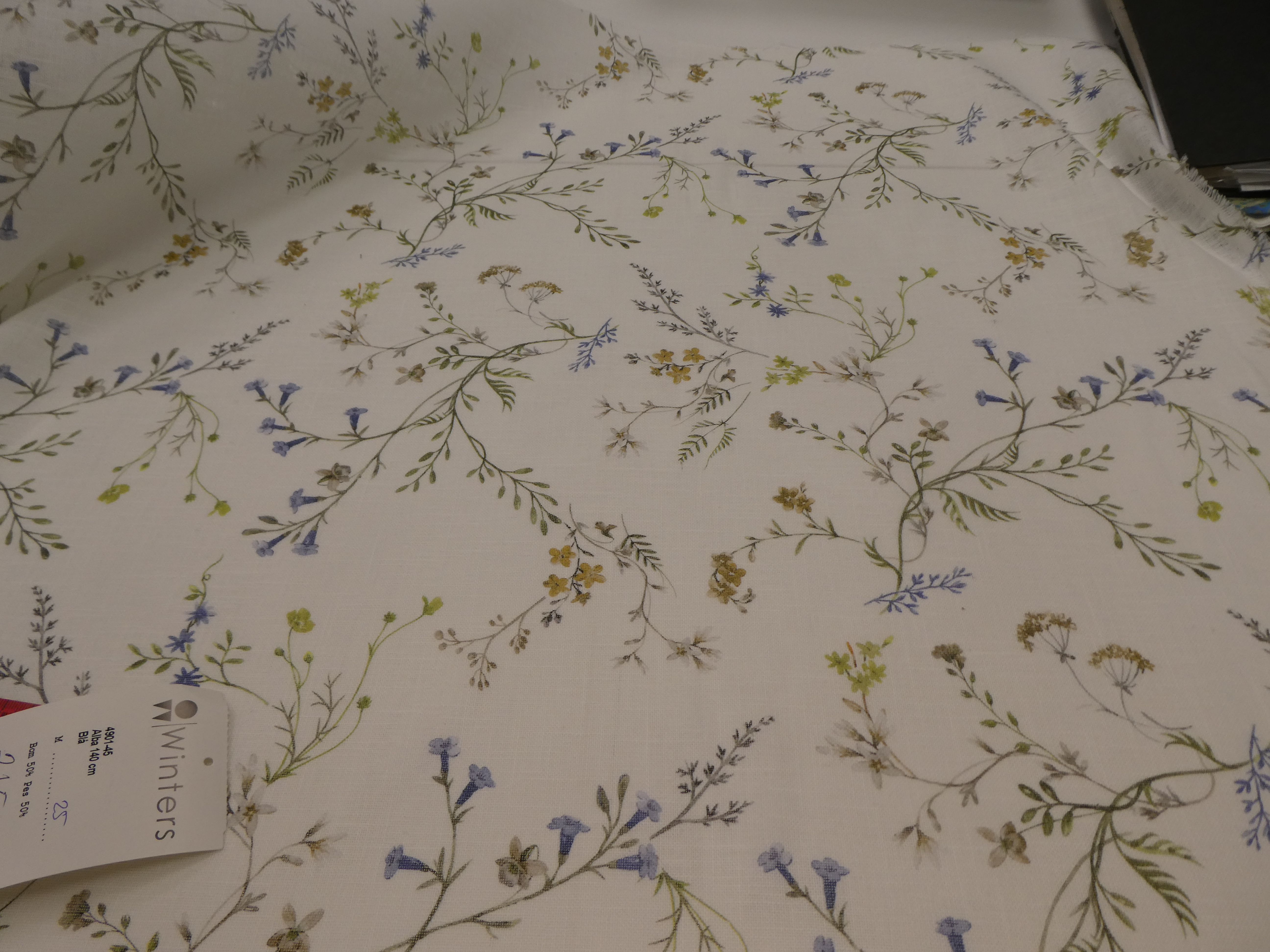 Alba ljus botten med små blommor i blå och gula toner