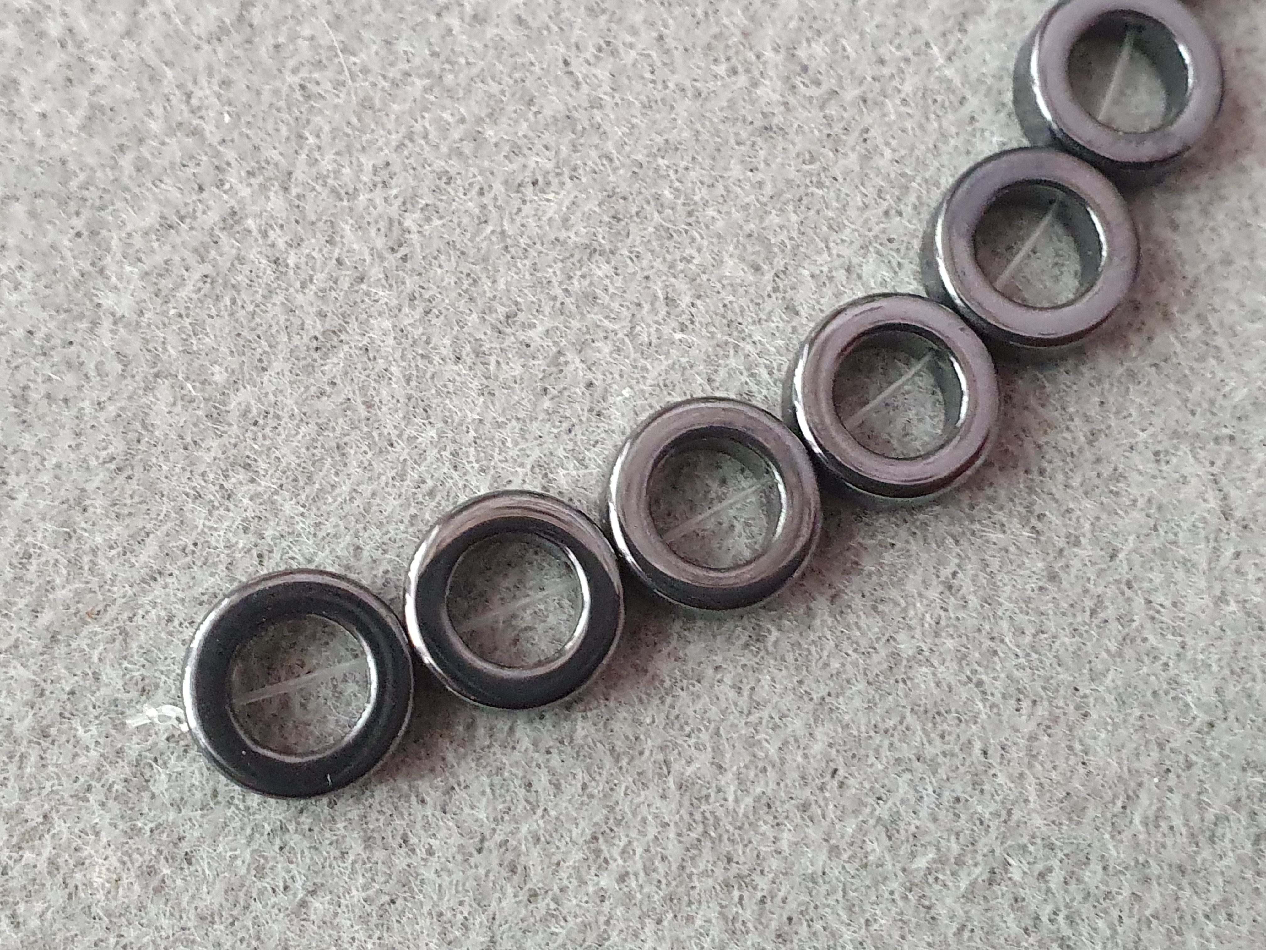 Hematit cirkel ca. 12mm, djup 4mm 5st/fp Pris/fp( pressat  ) (0,8)