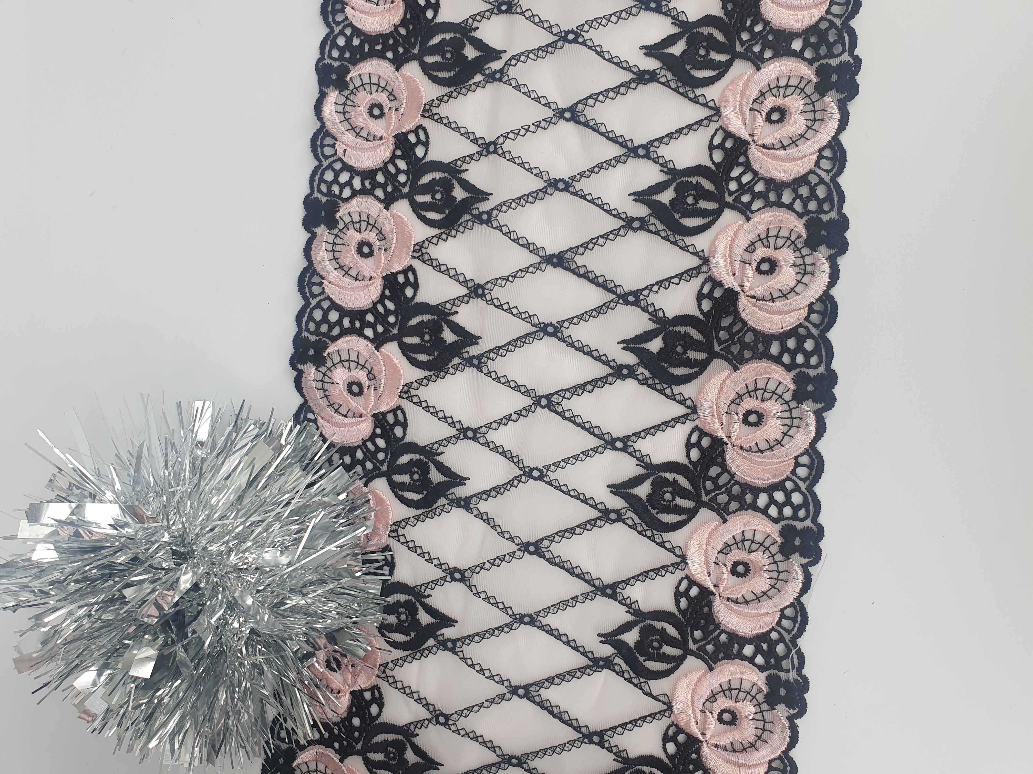 Black non-stretch lace with pink flowers on a white background