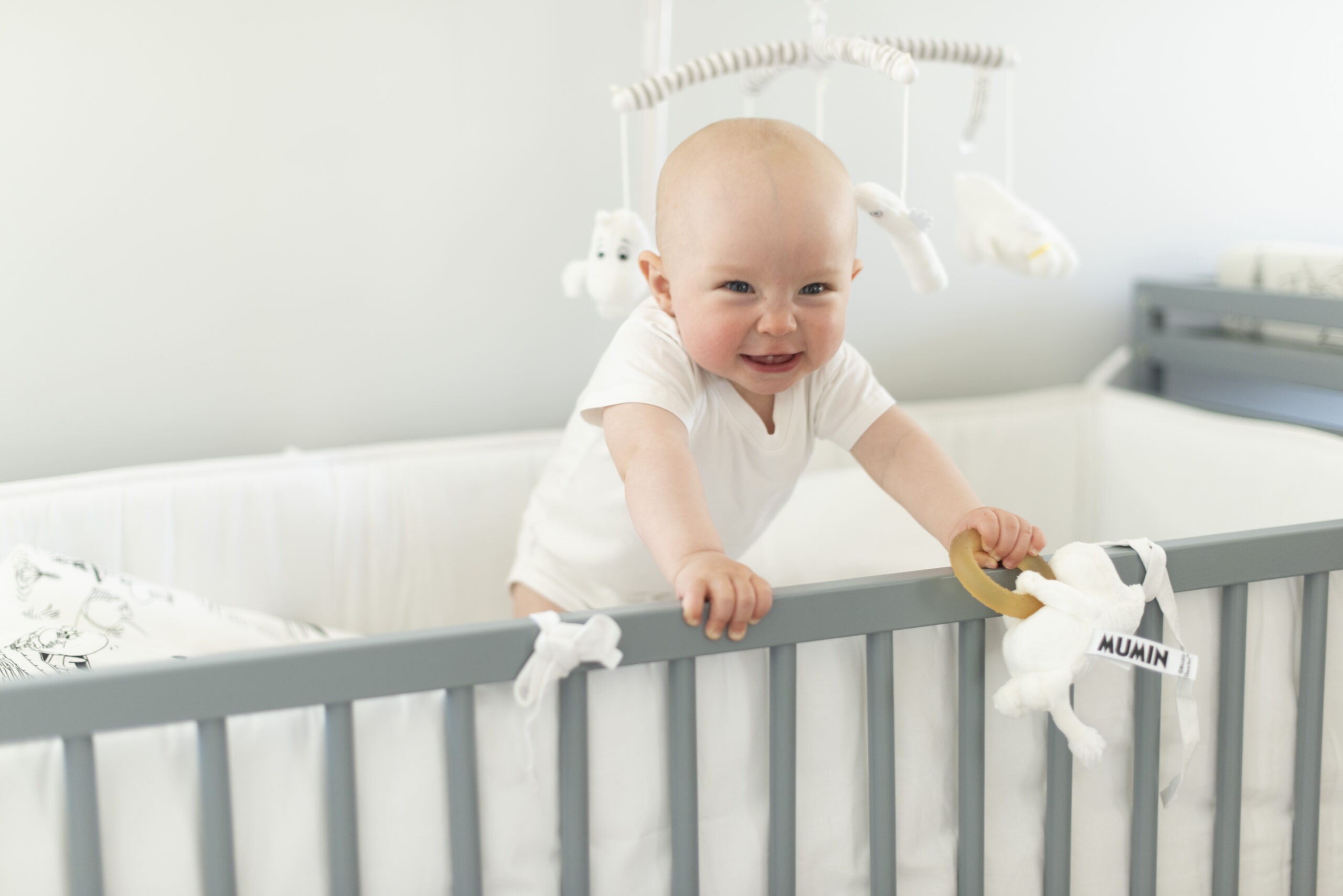 Barn i tremmeseng med babylegetøj
