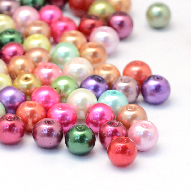 Glasvaxpärlor i mixade färger, runda 12 mm pärlor med 1 mm hål, visade i närbild på vit bakgrund. Pärlorna har en pärlemorskimrande yta i nyanser av rosa, grönt, lila, blått, guld och rött.
