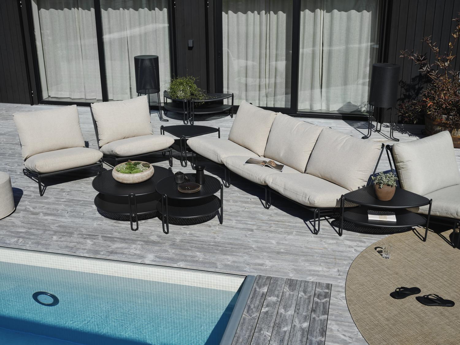 Blixt byggbar serie sommarmöbler. Visas här i poolmiljö med en soffa, två fåtöljer, två soffbord och ett bord i vinkel.