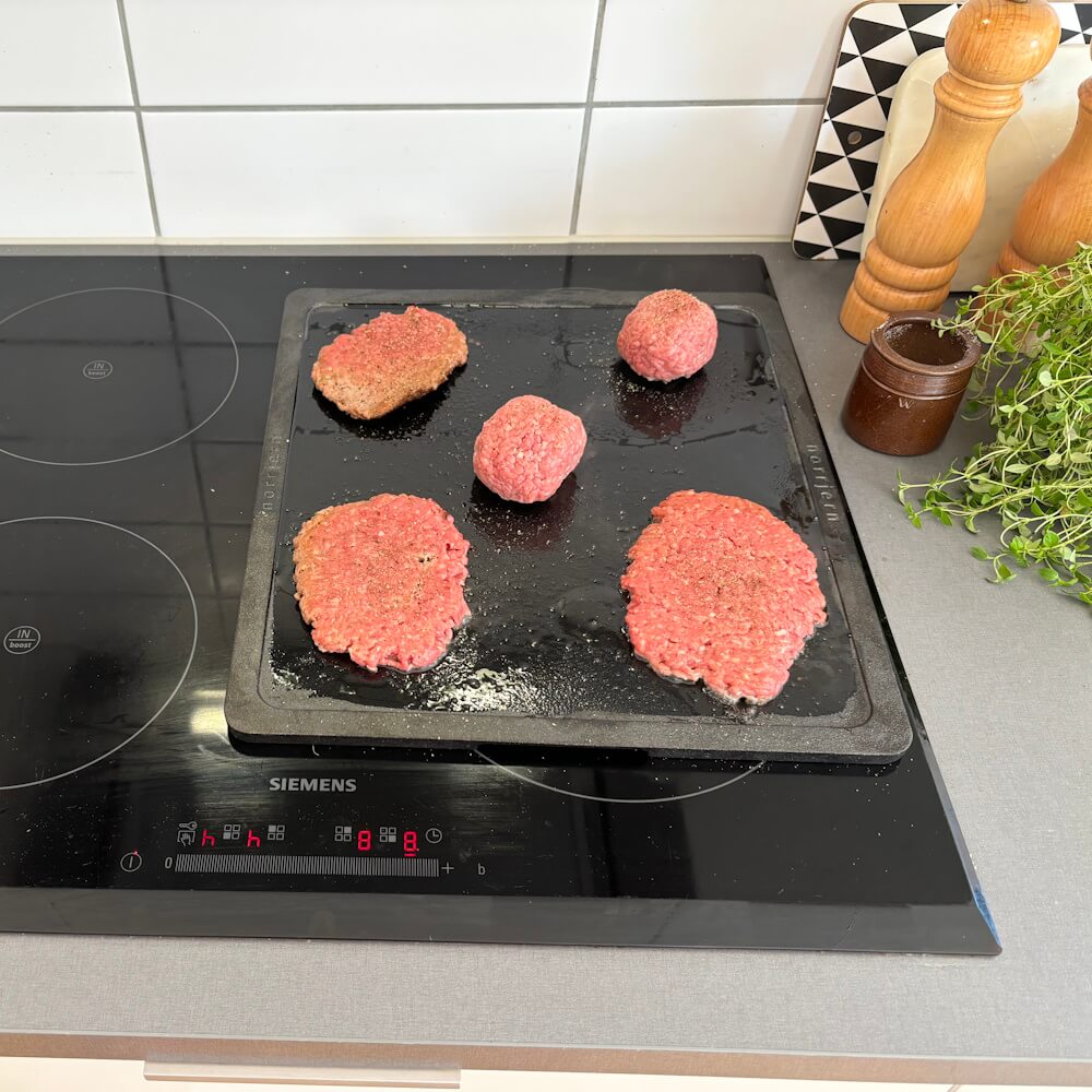 Takket være de små forhøjede kanter kan man også stege på denne bagesten uden at fedt løber ud.