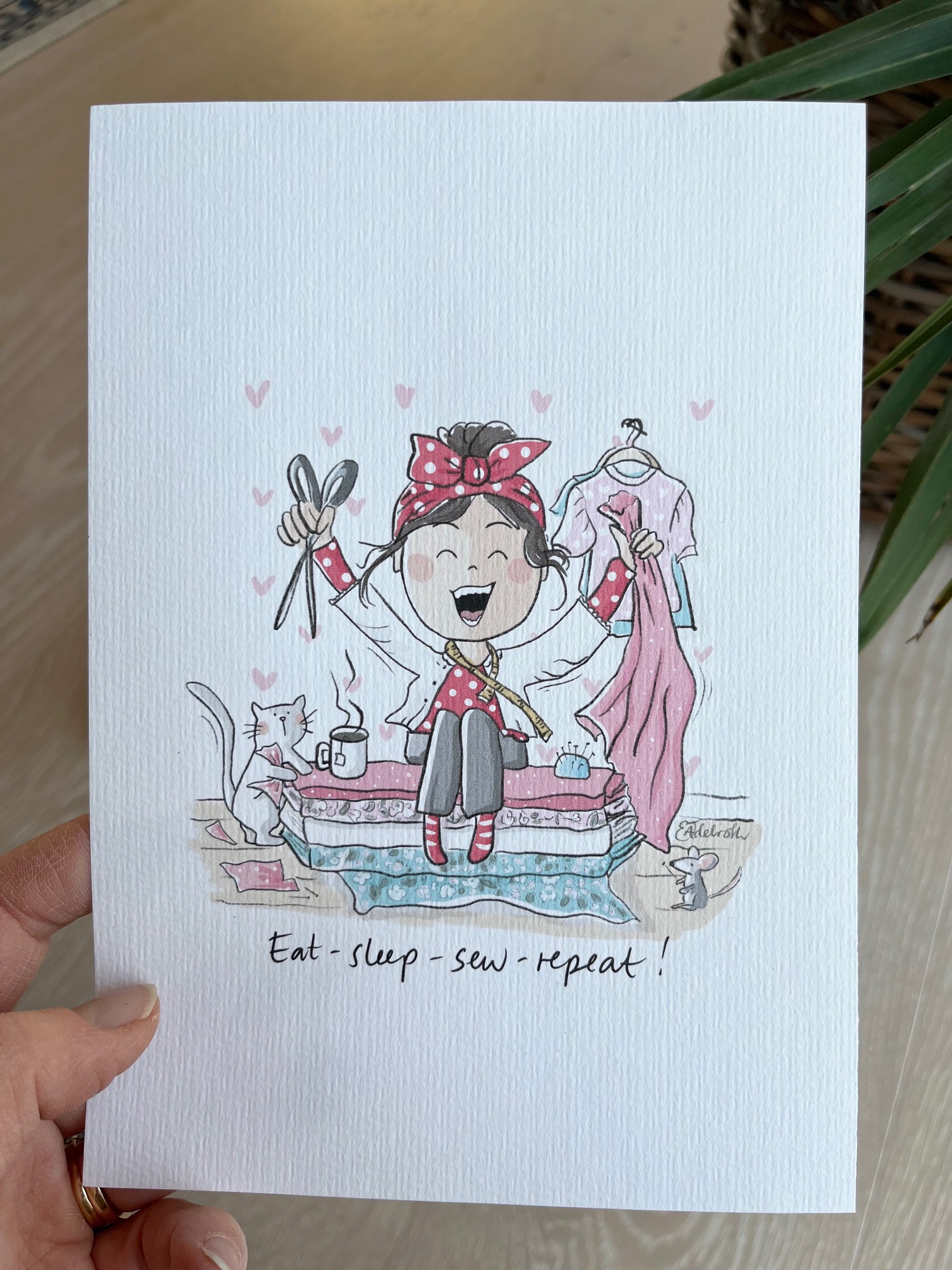 Signerat print A5 motiv flicka som sitter på en hög tyger och syr.