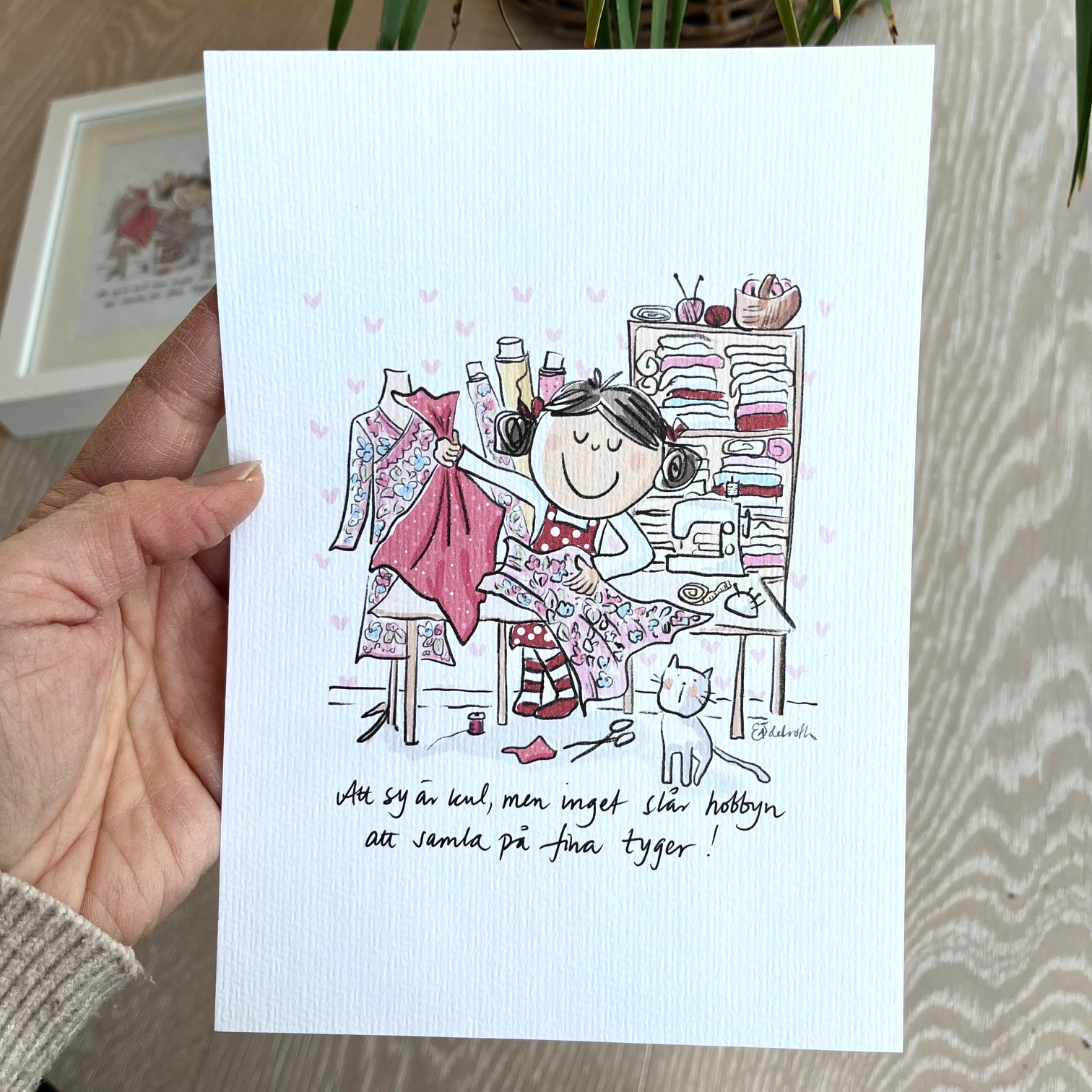 Signerat print A5. En flicka  i ett syrum med tyger. Att sy är kul men inget slår hobbyn att samla på fina tyger.