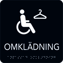 Taktil Skylt 150x150mm Omklädning handikapp, svart med vit text