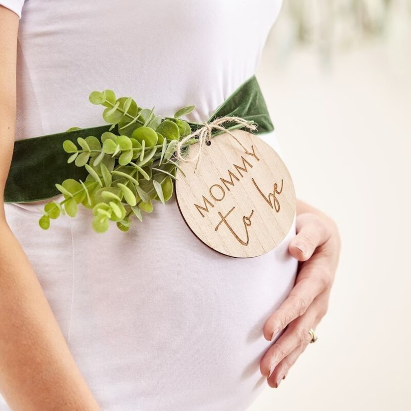 Babyshower sash Mummy To Be i grön sammet med träskylt och eukalyptus på gravid mage.