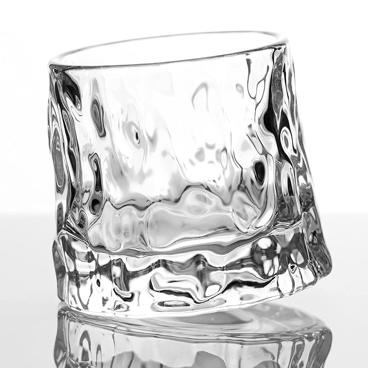 Whiskyglas on the rocks på ett spegelbord