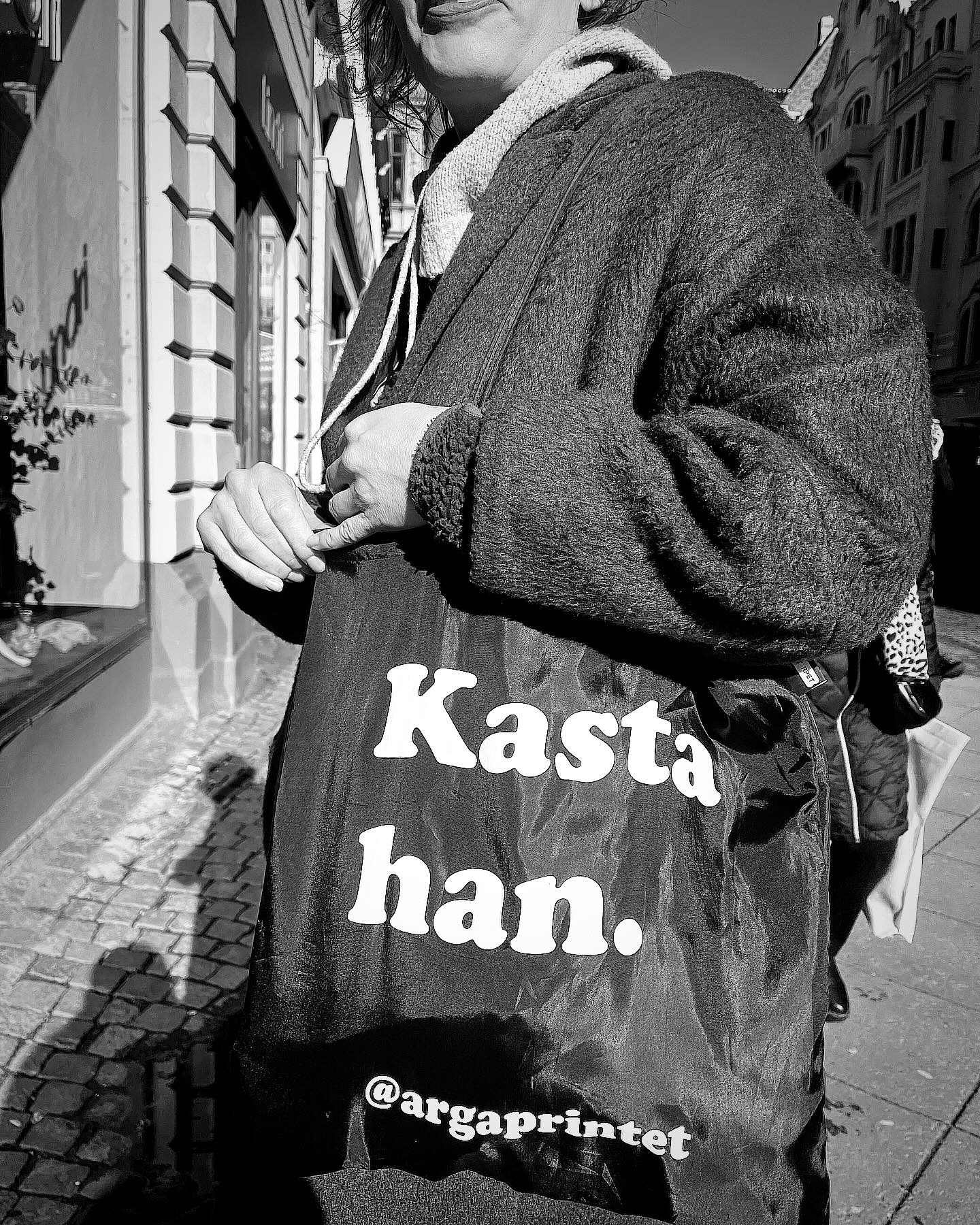 Bild på kvinna som bär tygkassen med texten Kasta han.