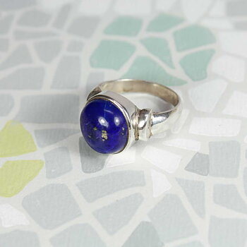 En silverring med en äkta infattad lapis lazuli en djupt blå sten med guldskimrande stänk av pyrit. Ringen är tillverkad för hand i en liten upplaga för hand av äkta sterlingsilver.