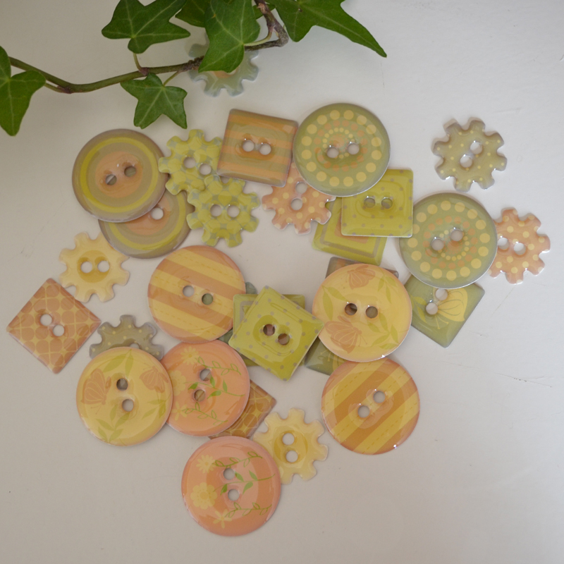Dekorknappar för scrapbooking och annat pyssel. Förpackning med 30 stycken i storlek 18-25 mm. 