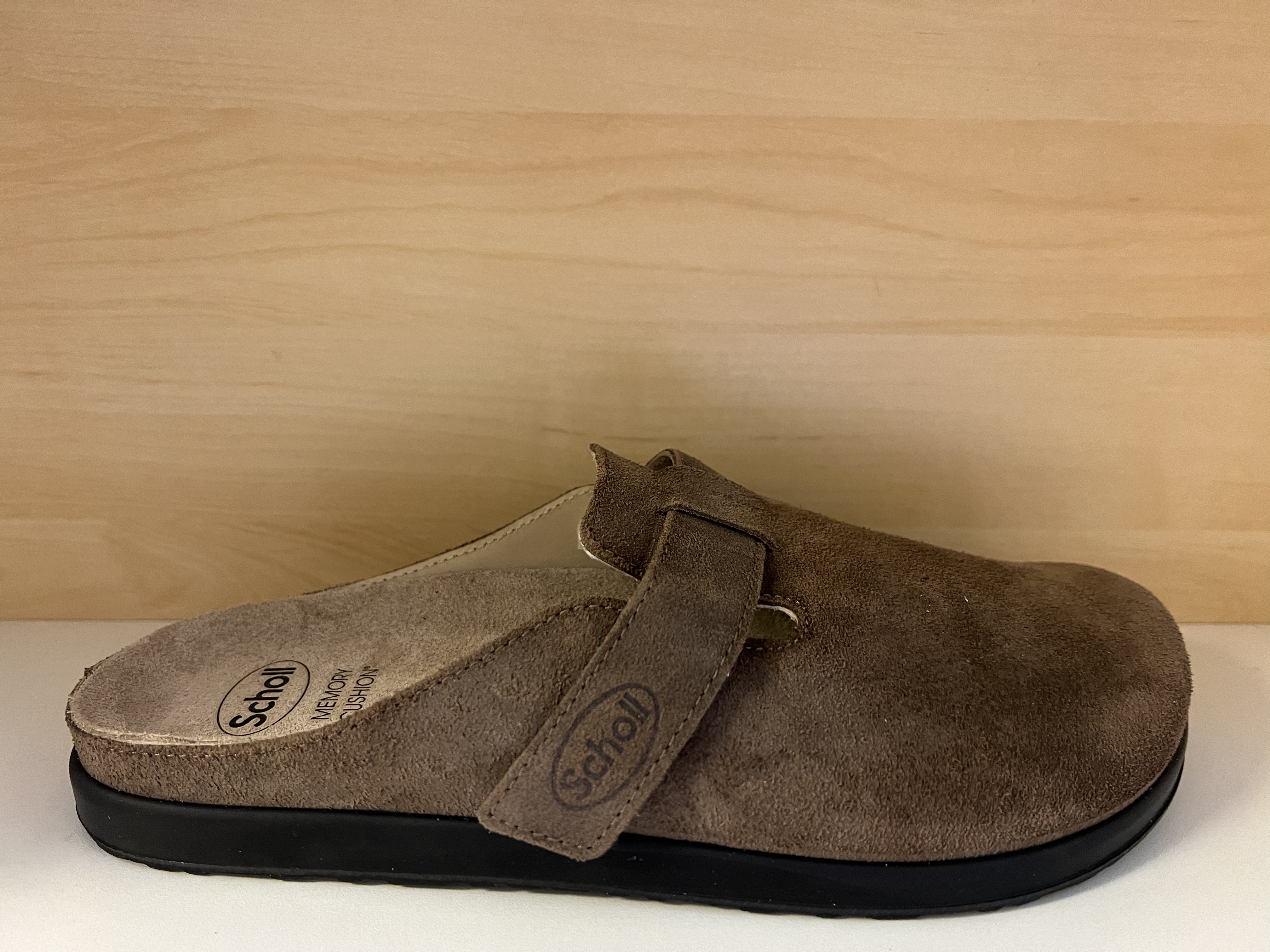 Scholl´s herrsko "Elio Strap" med Memory Cushion innersula som även är uttagbar. Brun mockskinn. Ställbar med kardborrband.