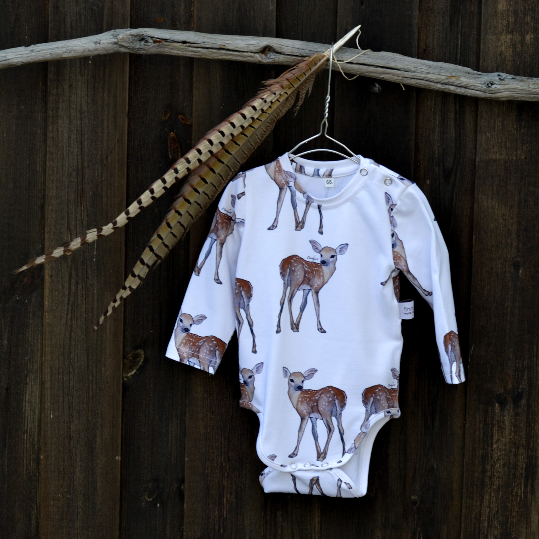 Vit babybody med handritat mönster av en prickig dovhjort  från Fina Frön, kollektion Skogen.