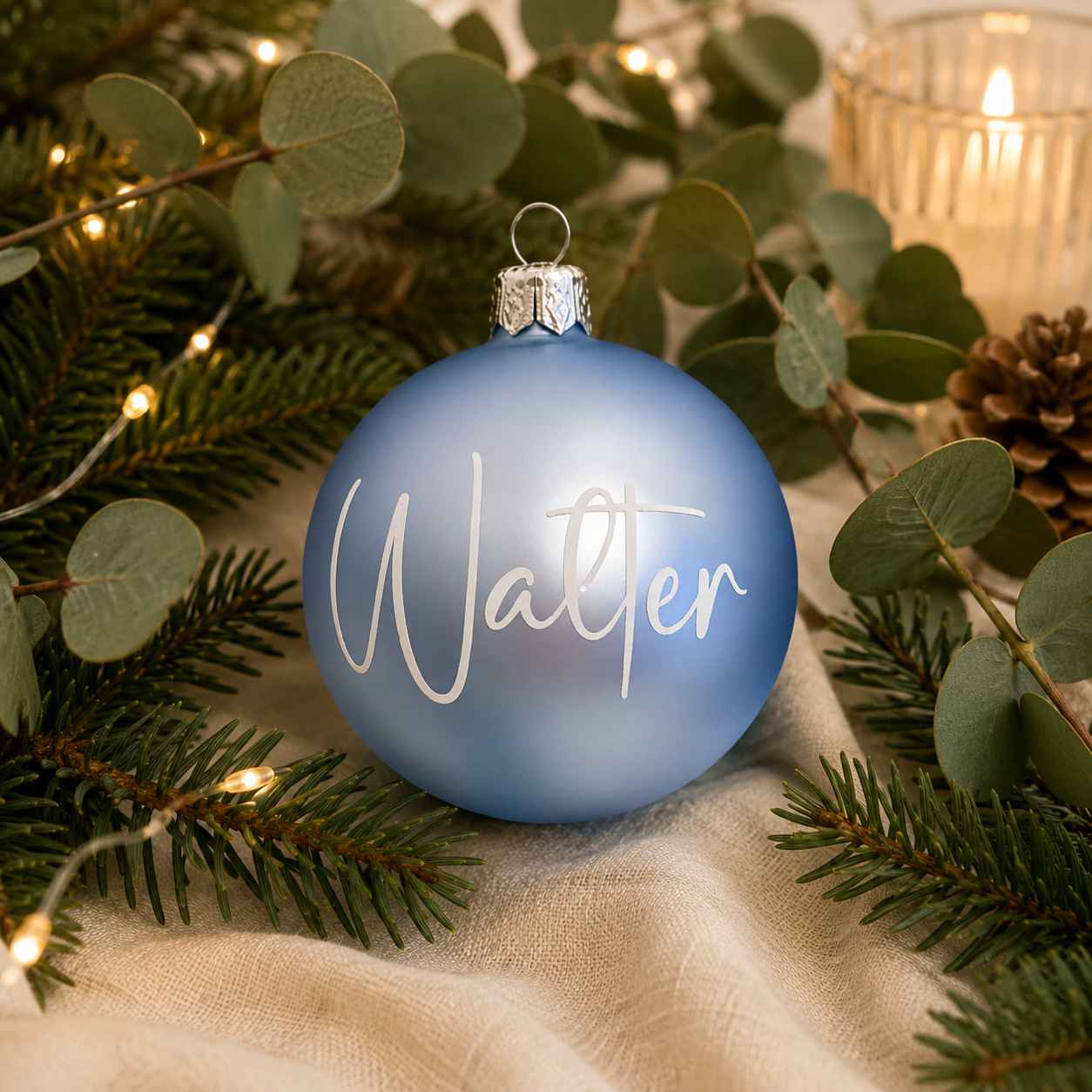 Personlig ljusblå glasjulkula med namnet Walter i stämningsfull julmiljö