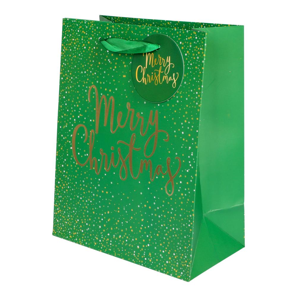 Grön presentpåse med guldfolierad text "Merry Christmas", guldfärgade stjärnor och gröna handtag – perfekt till julklappar och presenter.