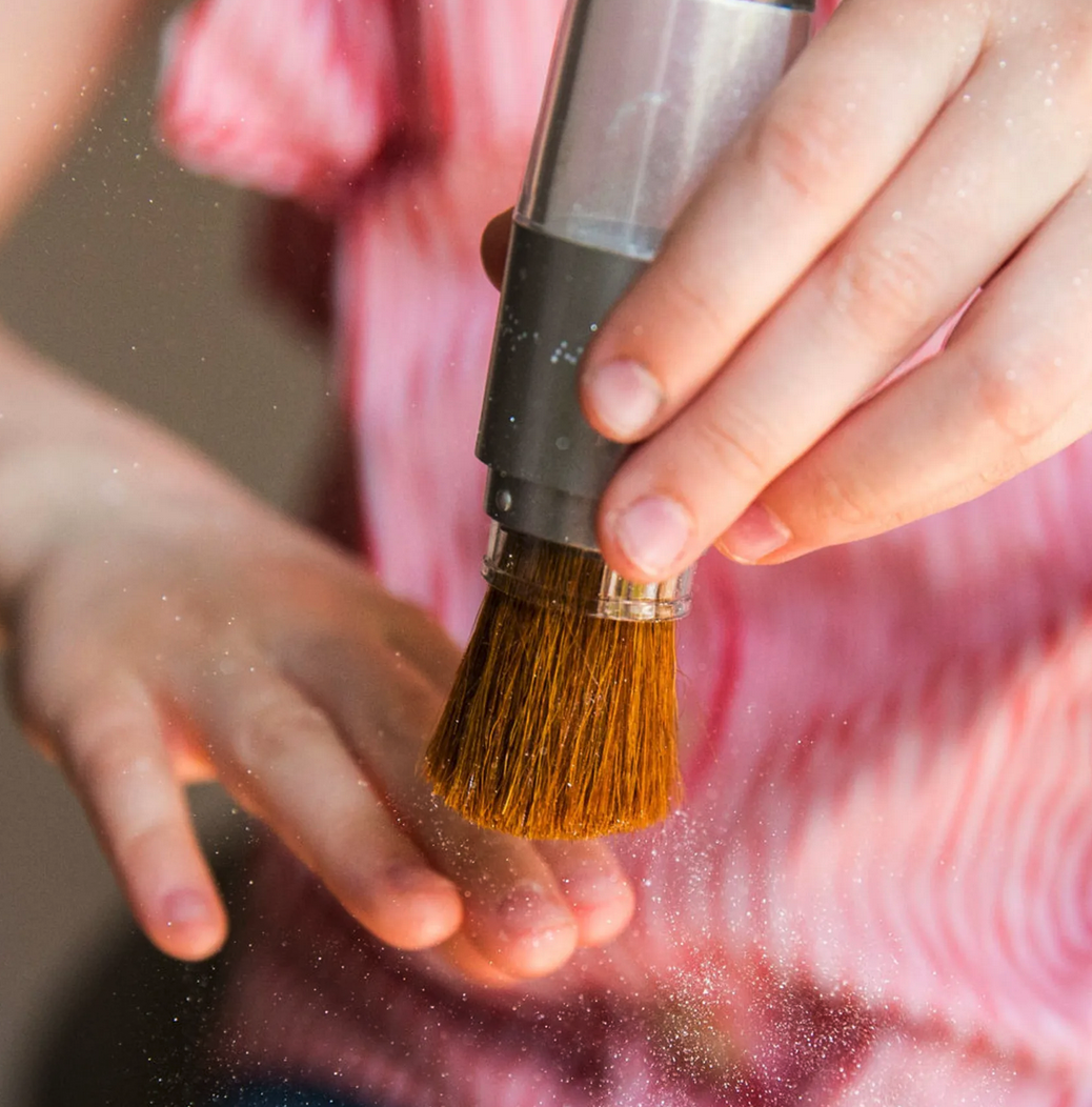 Børn børster glitter med børste på hænderne