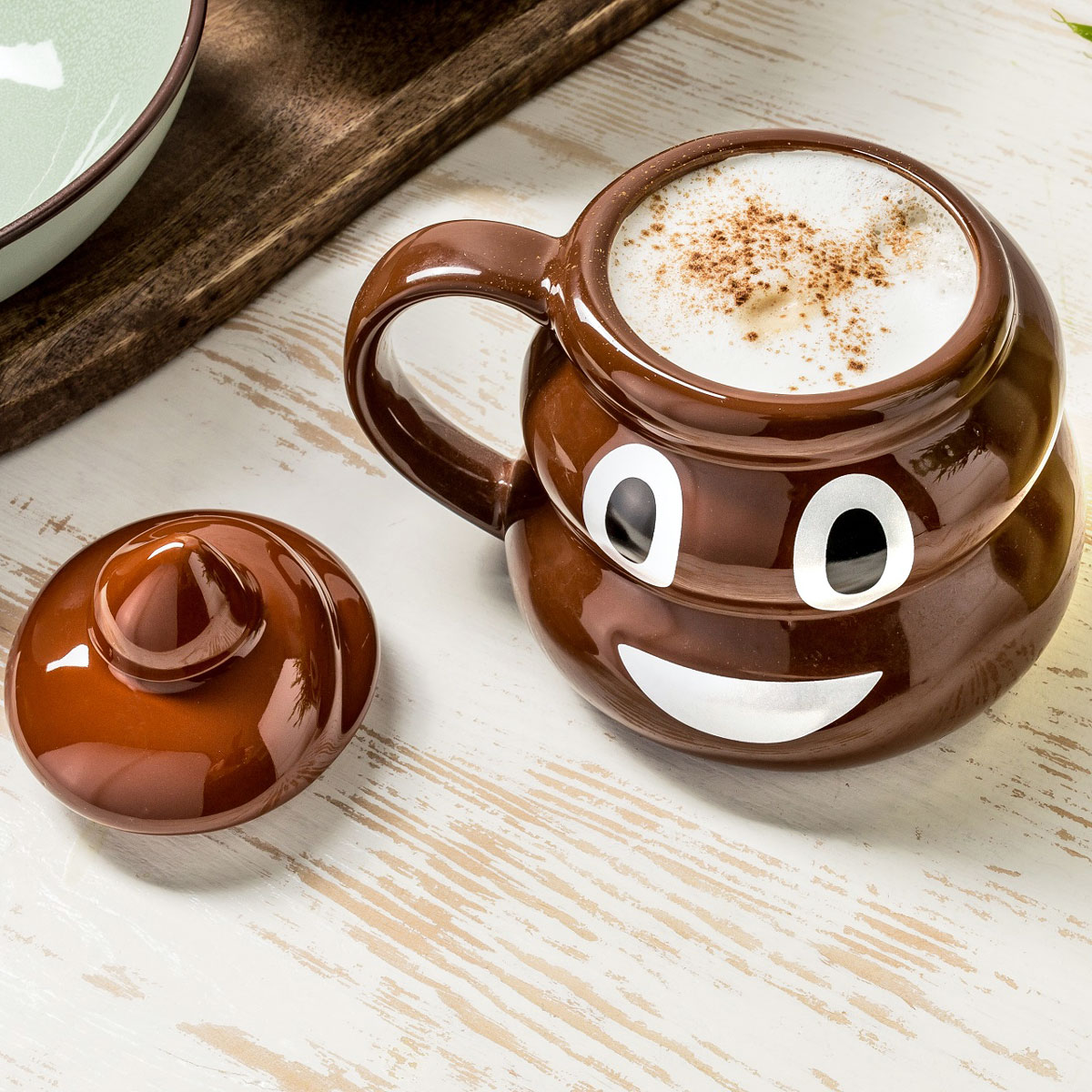 Poop-Emoji-Mugg fylld med kaffe och locket bredvid
