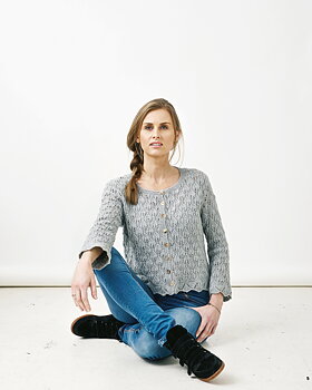 sittande kvinna med kofta med bladmönster i esther
