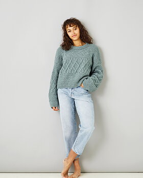 Ung kvinna i jeans och tröja med struktur i Alice