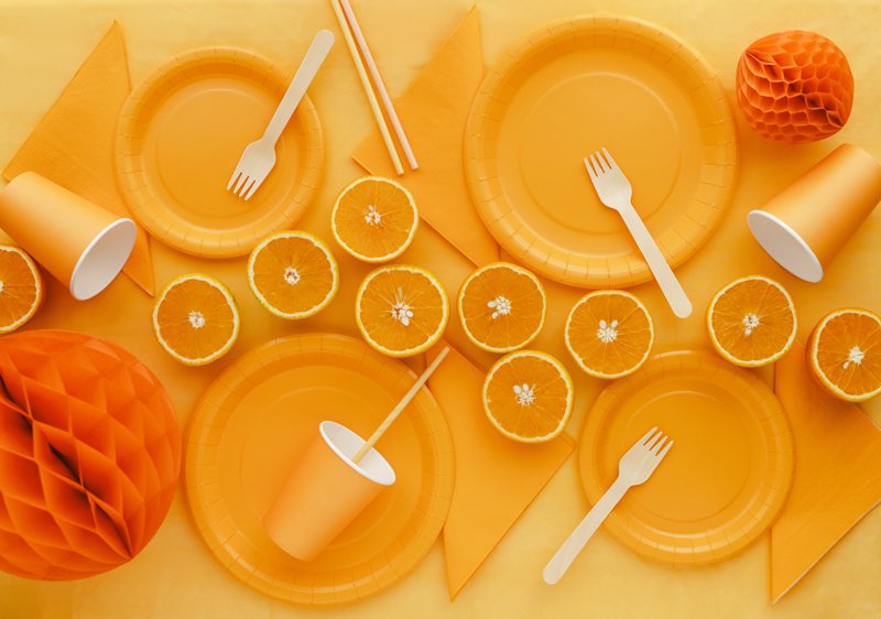 Orange servetter tillsammans med matchande tallrikar och muggar för Halloween och höstfest.