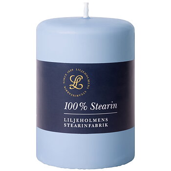 Ett ljusblått blockljus från Liljeholmens Stearinfabrik med en mörkblå etikett. På etiketten står det ”100 % Stearin” och ”Liljeholmens Stearinfabrik” tillsammans med en guldfärgad logotyp och texten ”Since 1839”.