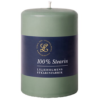 Ett grönt blockljus från Liljeholmens Stearinfabrik med en mörkblå etikett där det står "100 % Stearin". Etiketten har även Liljeholmens logotyp och texten "LILJEHOLMENS STEARINFABRIK" i vitt.