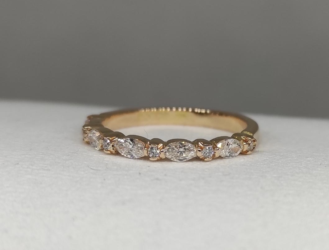 Ring Maggie i 18K guld med briljantslipade SI-diamanter liggande mot underlag