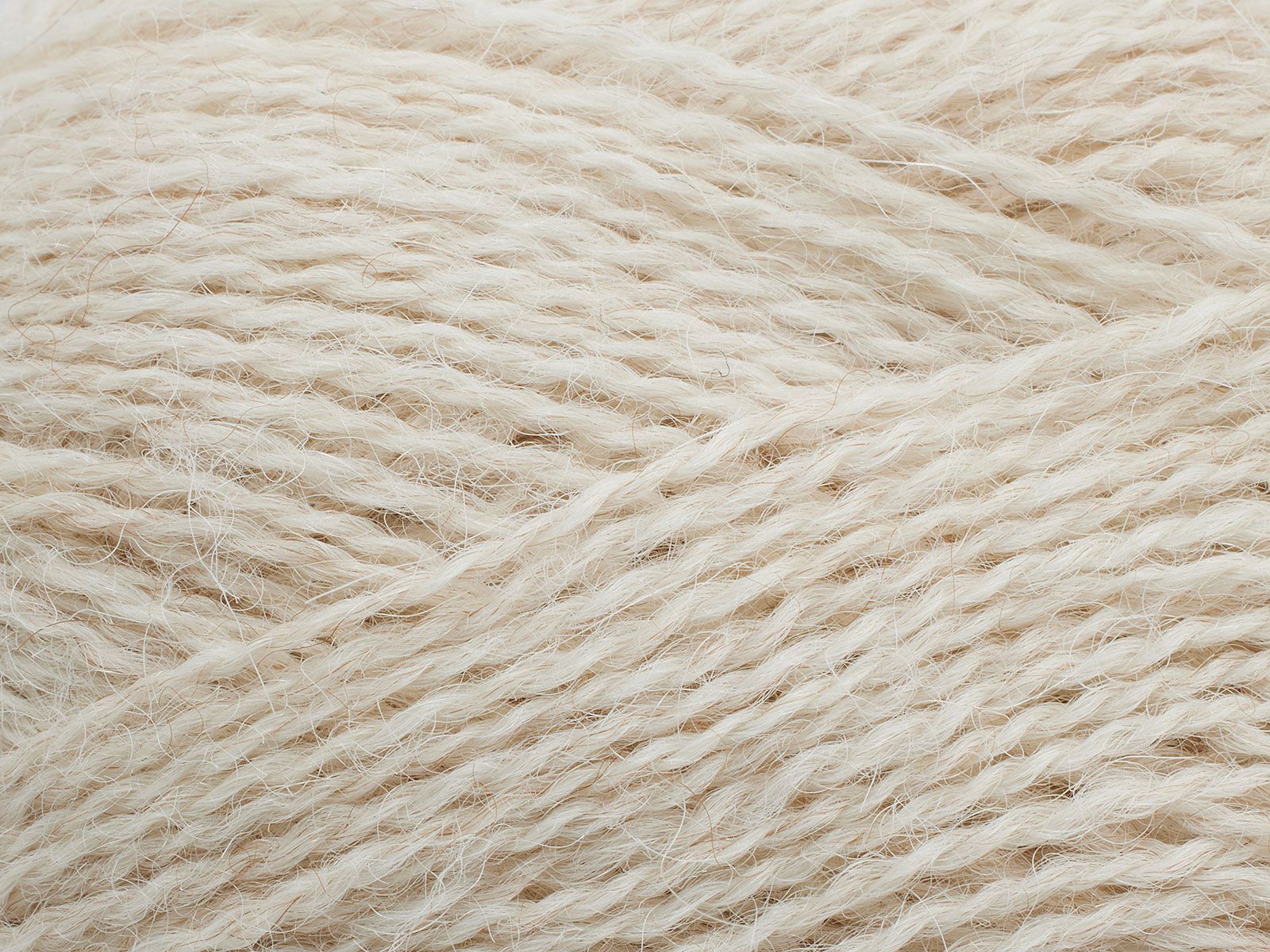 En närbild på Filcolanas tunna alpackagarn Alva i ljust beige