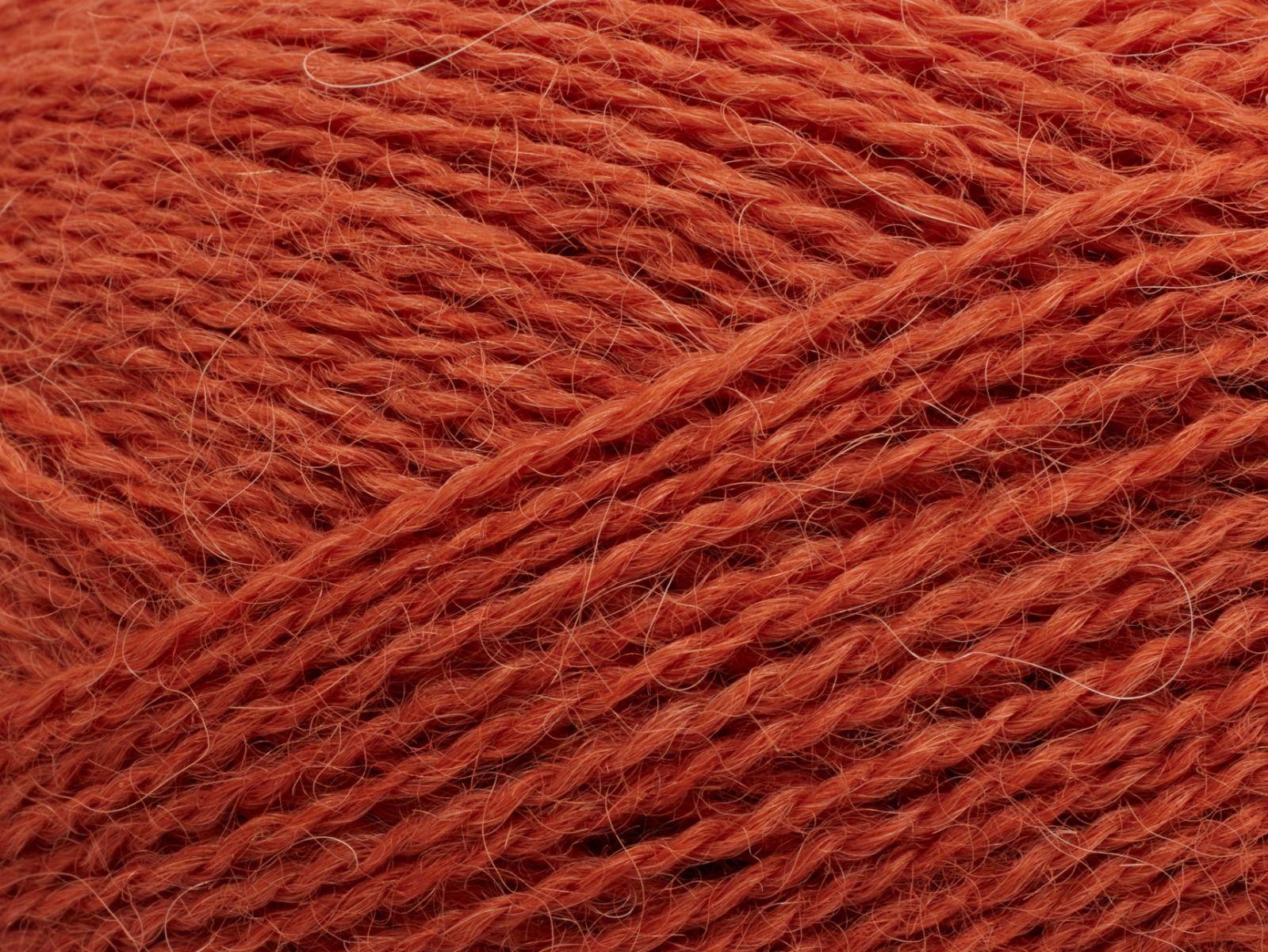 En närbild på Filcolanas tunna alpackagarn Alva i lite mörkare orange