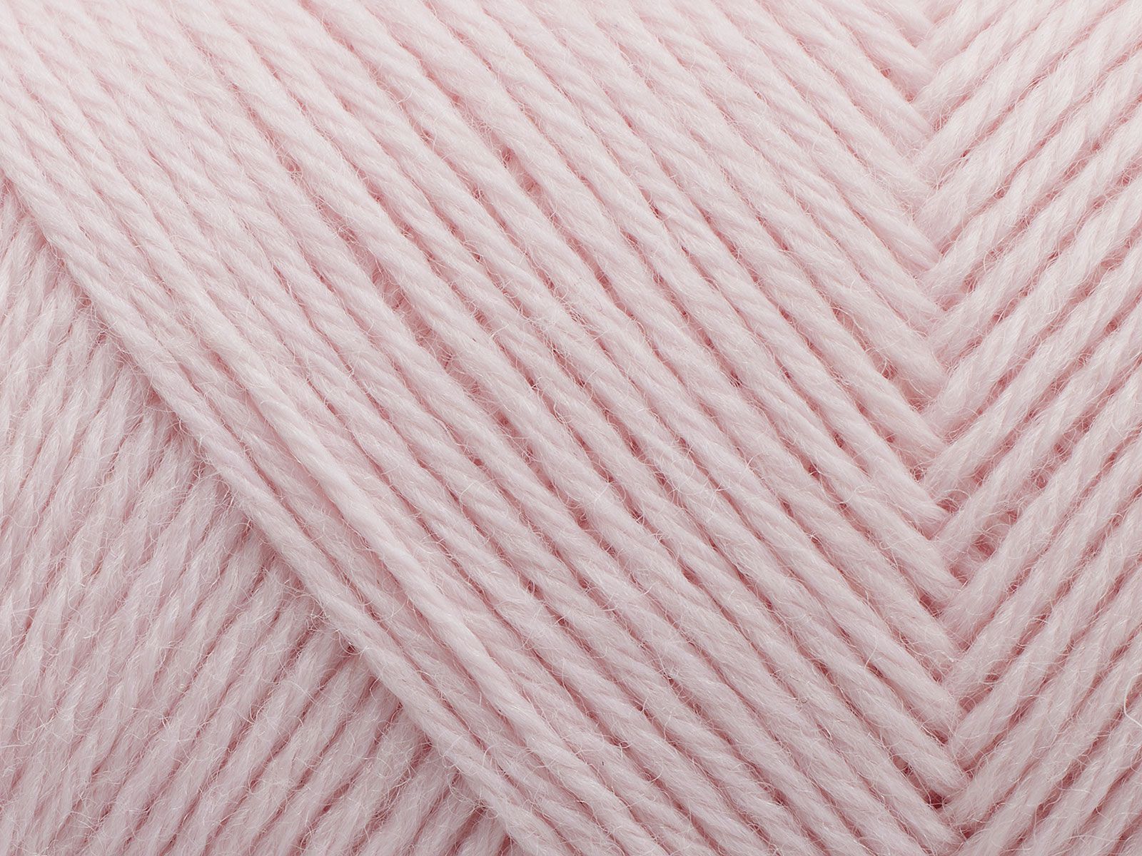 En närbild på ett nystan av Filcolanas garn Arwetta i merinoull i ljust rosa