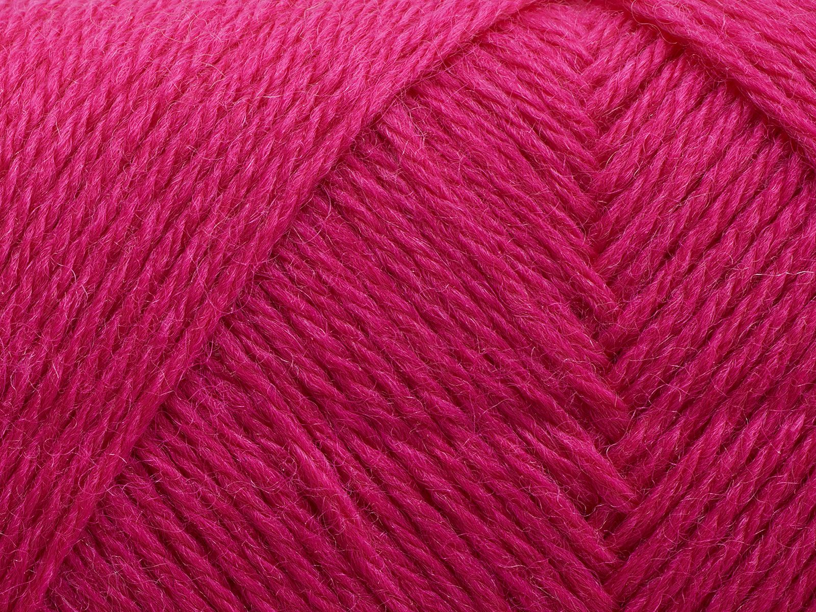En närbild på ett nystan av Filcolanas garn Arwetta i merinoull i cerise