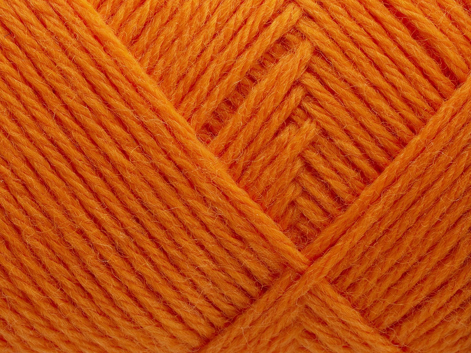 En närbild på ett nystan av Filcolanas garn Arwetta i merinoull i ljus klar orange