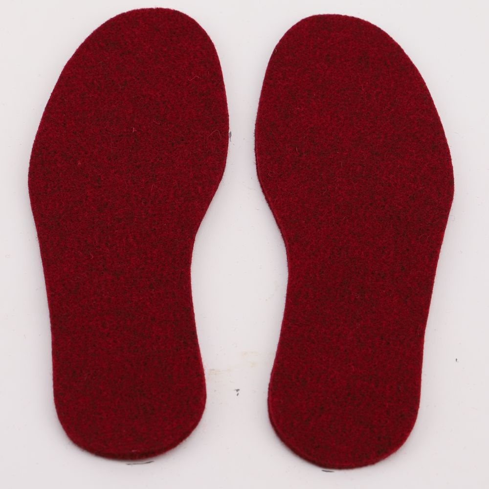 A pair of felted wool insoles in the color red