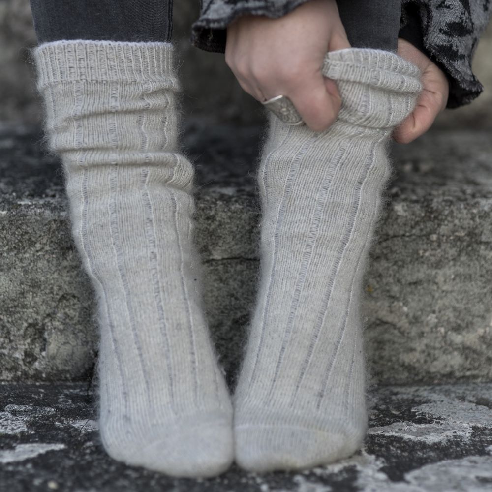 Två fötter med tjocka mohairsockar i ljusgrått