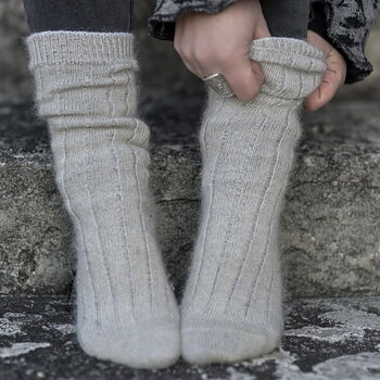 Två fötter med tjocka mohairsockar i ljusgrått