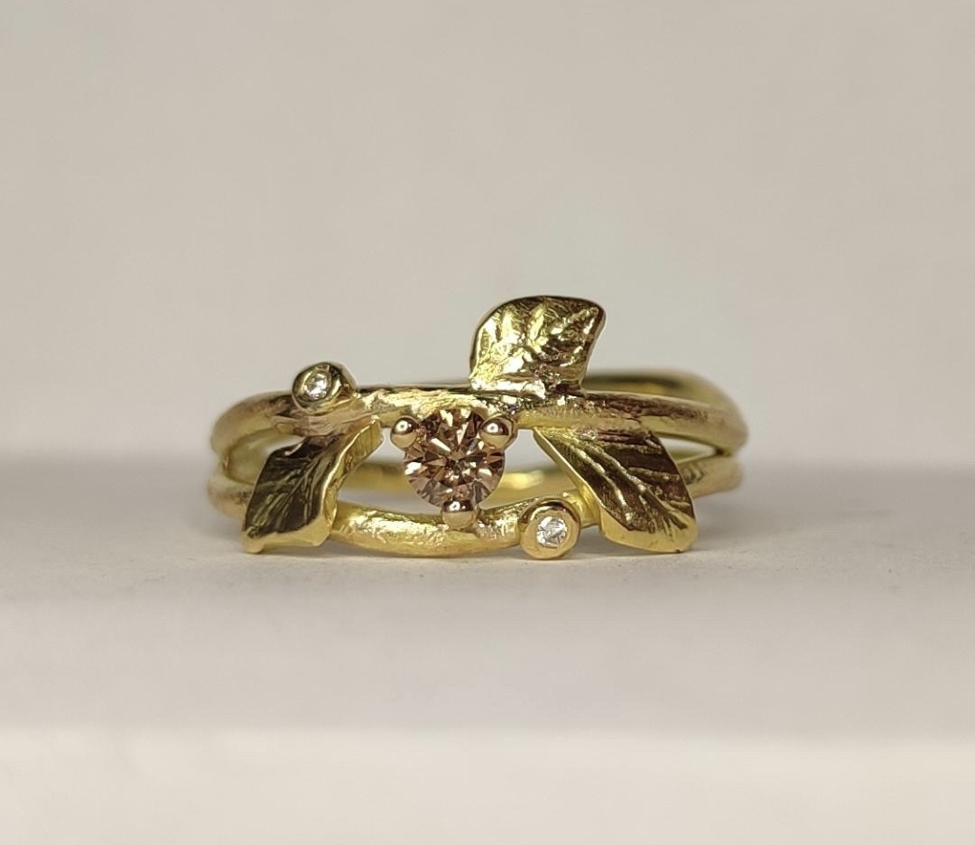 Liggande ring "Growing Strong" i 18K guld med champagnefärgad och vita diamanter