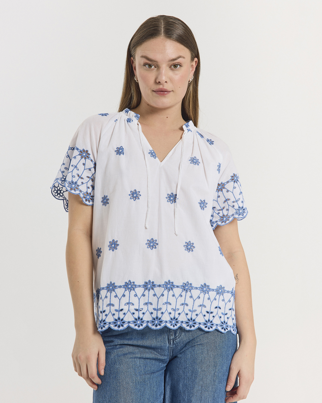 Blus Iddi vit med blå broderade blommor